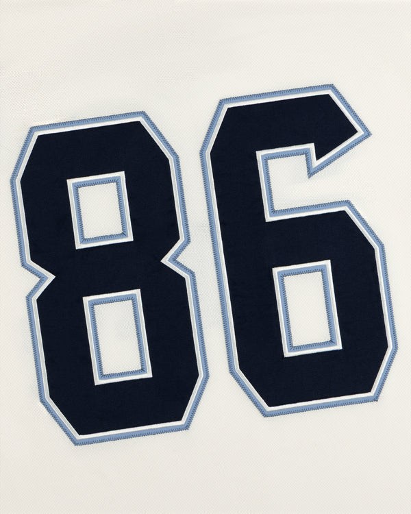 The number 86 in dark navy blue with light blue and white outlines on a white Team Aimé Hockey Jersey.