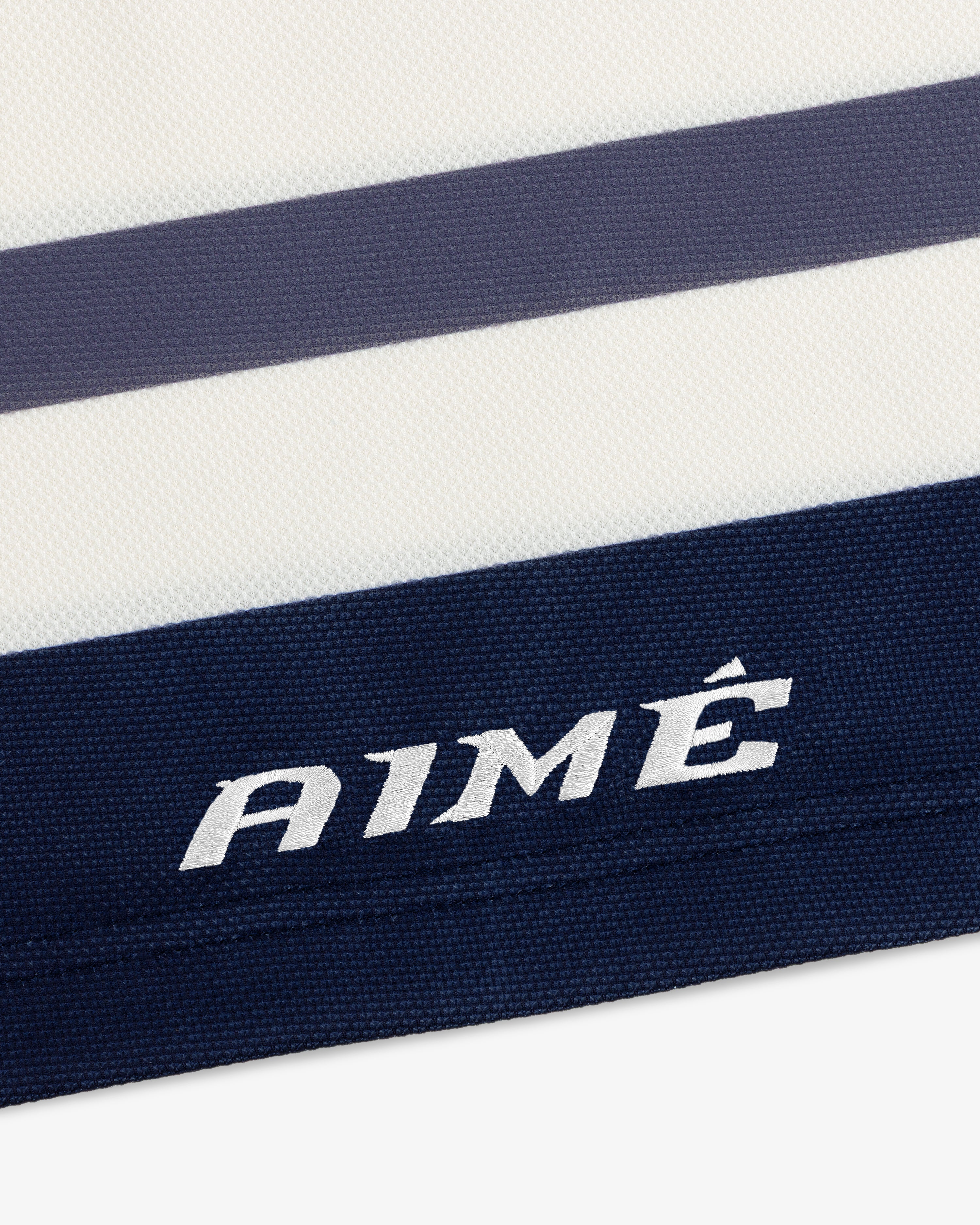 Team Aimé Hockey Jersey featuring white and navy blue stripes with the word AIMÉ embroidered on a navy stripe.