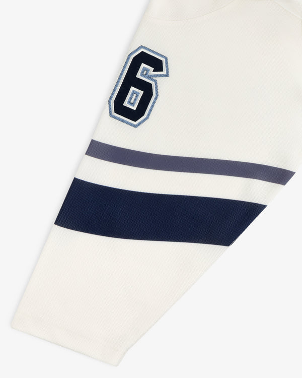 Off-white Team Aimé Hockey Jersey sleeve featuring the number 6 in navy and blue with two matching horizontal stripes.
