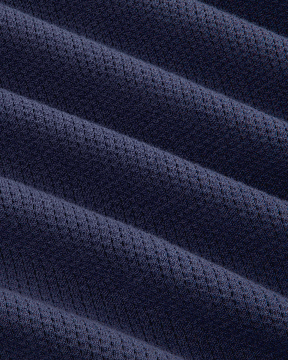 Close-up of Long-Sleeve Mesh Football Tee’s dark blue fabric, featuring diagonal ridges and a subtle waffle texture.