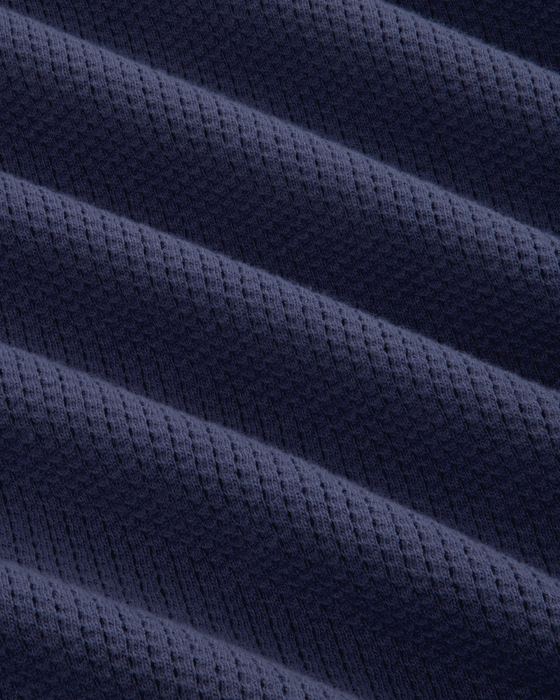 Close-up of Long-Sleeve Mesh Football Tee’s dark blue fabric, featuring diagonal ridges and a subtle waffle texture.