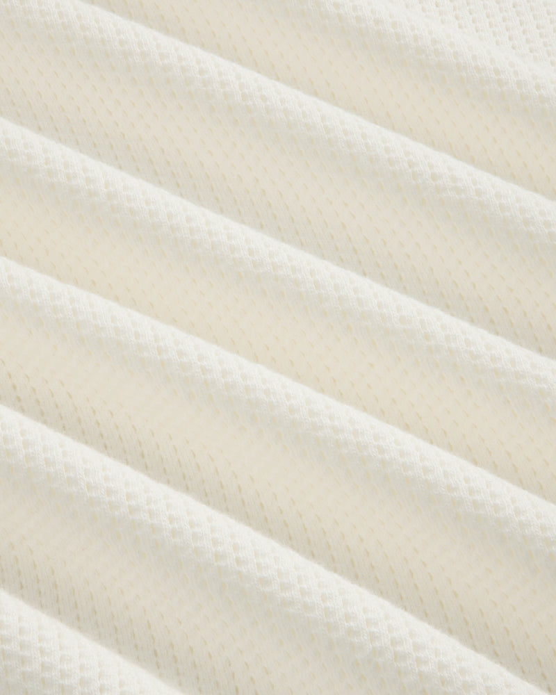 Close-up of soft, white mesh from the Long-Sleeve Mesh Football Tee, featuring ribbed texture and subtle patterns.