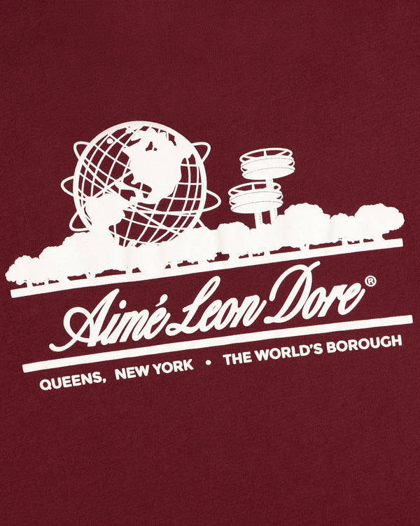 Unisphere Tee: Maroon shirt with white globe, trees, and Aimé Leon Dore Queens New York The World’s Borough graphics.