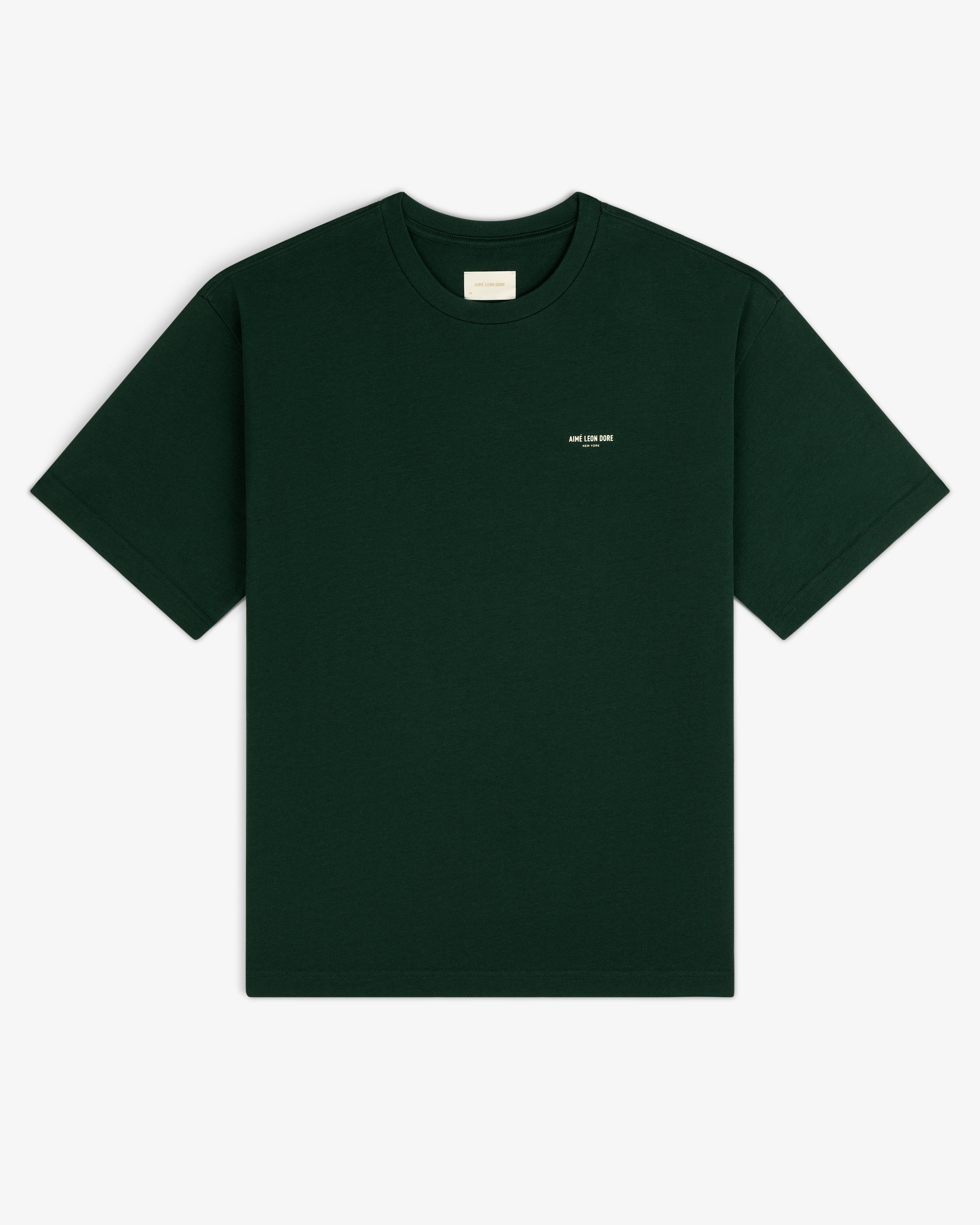 Micro Logo Tee in dark green with a small white chest label, shown on a white background.