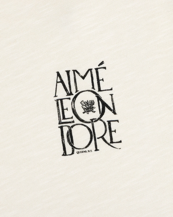 Stacked Logo Slub Tee with Aimé Leon Dore text, flower graphic, and Queens, N.Y. on white textured fabric.