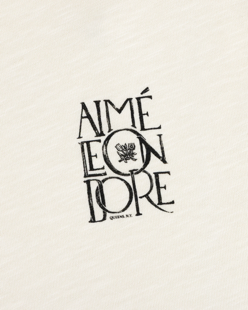 Stacked Logo Slub Tee with Aimé Leon Dore text, flower graphic, and Queens, N.Y. on white textured fabric.