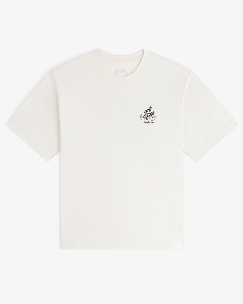 Aimé Tour Graphic Tee: White short-sleeve shirt with small black graphic and text on the left chest area.