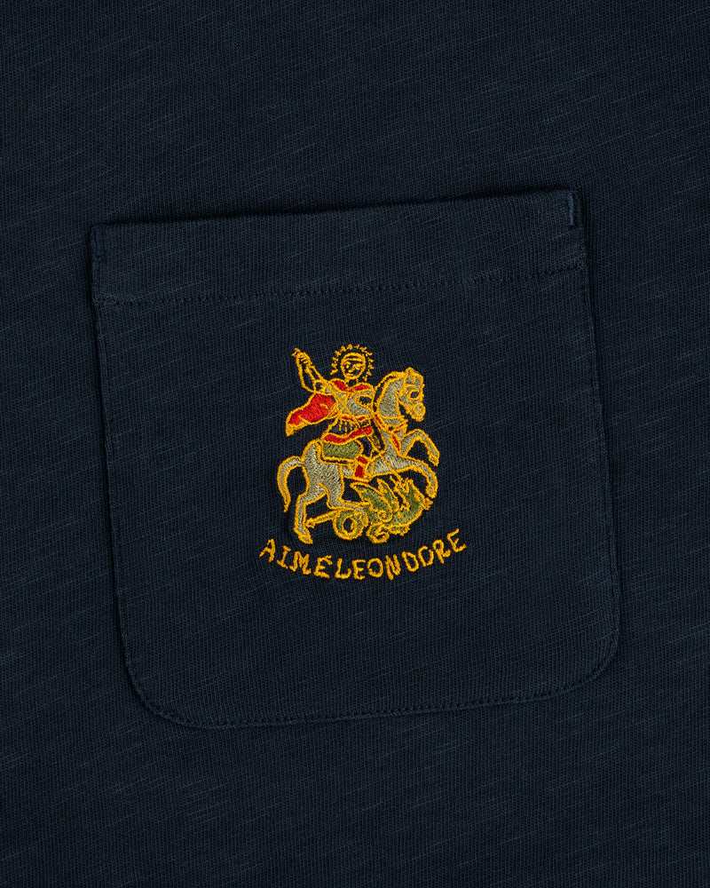 Navy Saint George Slub Pocket Tee with embroidered horseback figure, red cape, dragon, and AIME LEON DORE text.