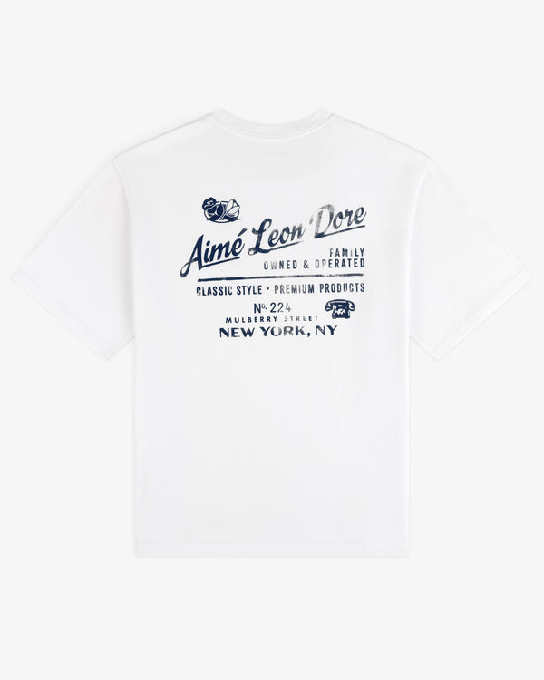 Neighborhood Tee: White t-shirt with blue Aimé Leon Dore text and New York, NY address on the back.