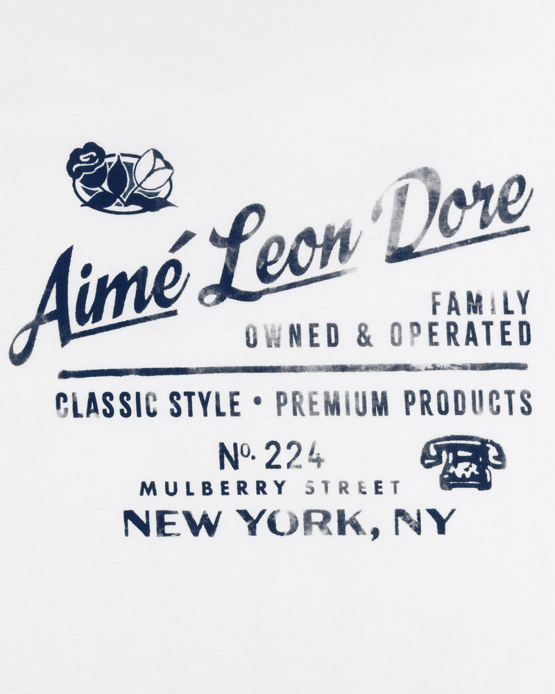 Neighborhood Tee: Navy Aimé Leon Dore logo, roses, vintage phone graphic on white background.