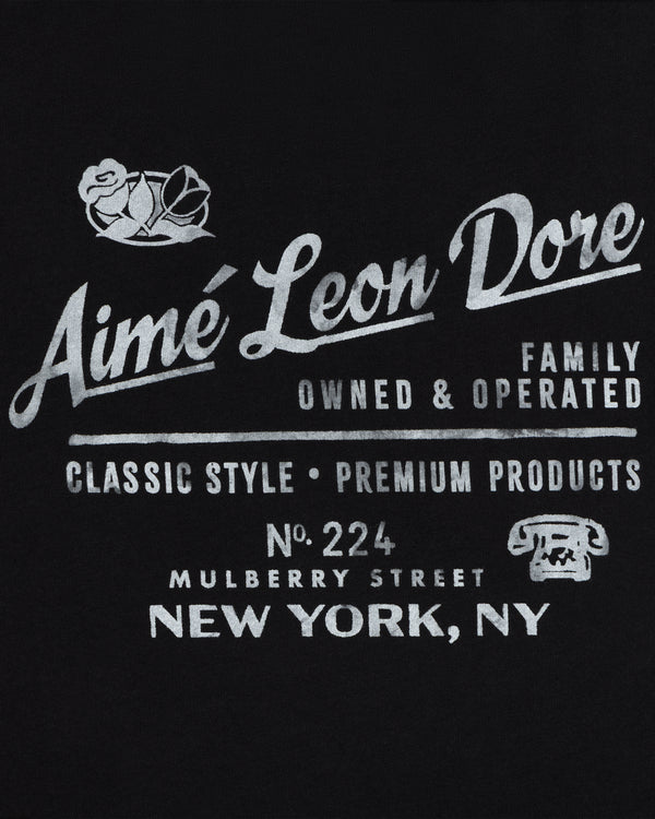 Neighborhood Tee: Black shirt with white Aimé Leon Dore text, classic Mulberry St. style, premium New York product.