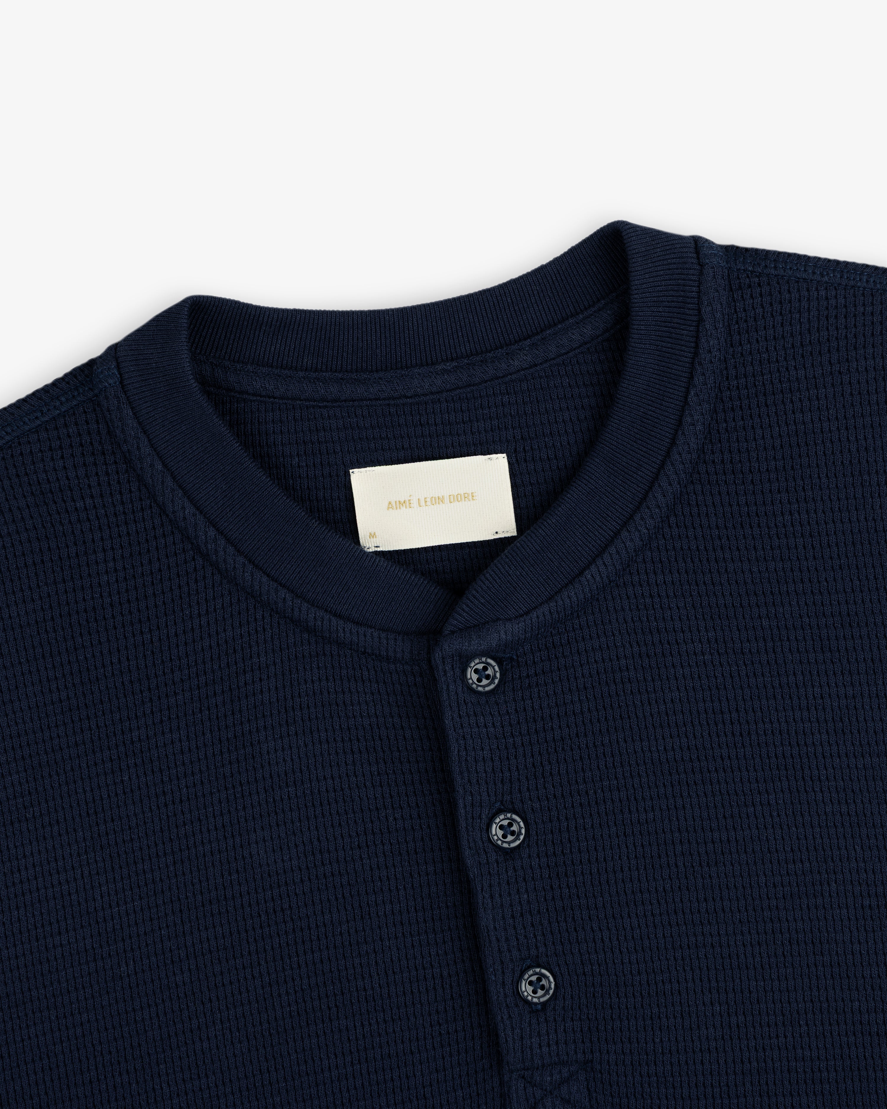 Dark navy Long-Sleeve Waffle Henley with a waffle-knit texture, three-button placket, and crew neckline.