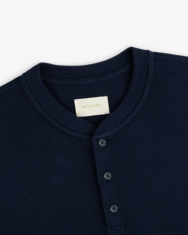 Dark navy Long-Sleeve Waffle Henley with a waffle-knit texture, three-button placket, and crew neckline.