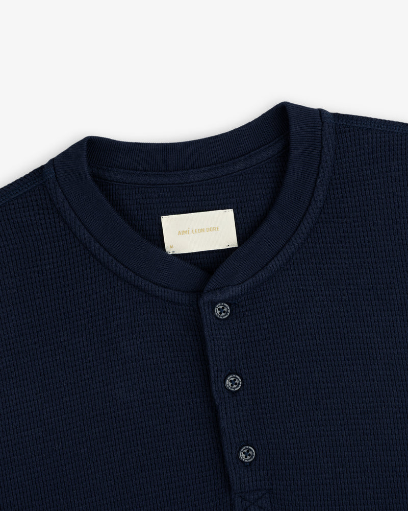 Dark navy Long-Sleeve Waffle Henley with a waffle-knit texture, three-button placket, and crew neckline.