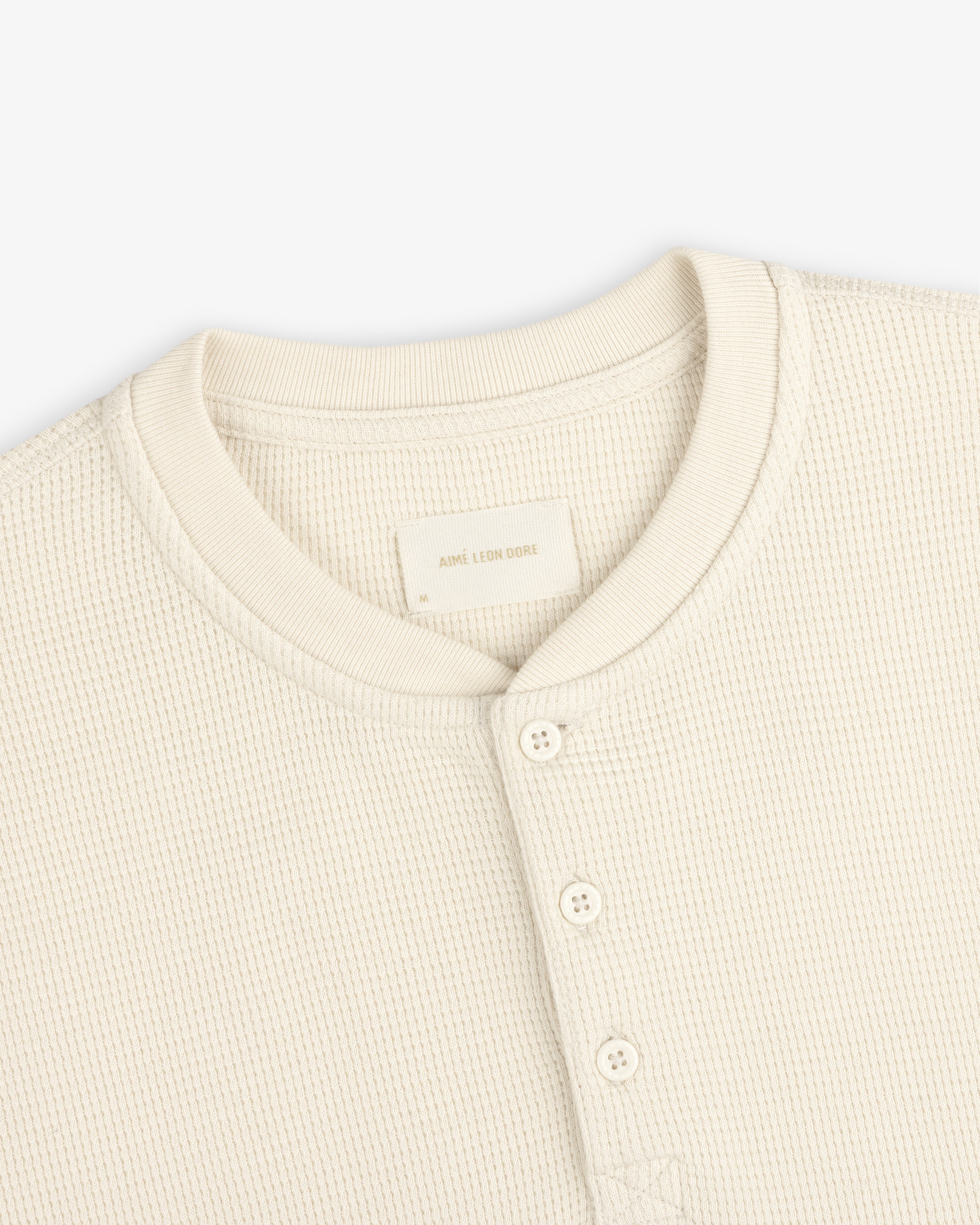 Cream-colored Long-Sleeve Waffle Henley shirt with a waffle-knit texture and a button placket.
