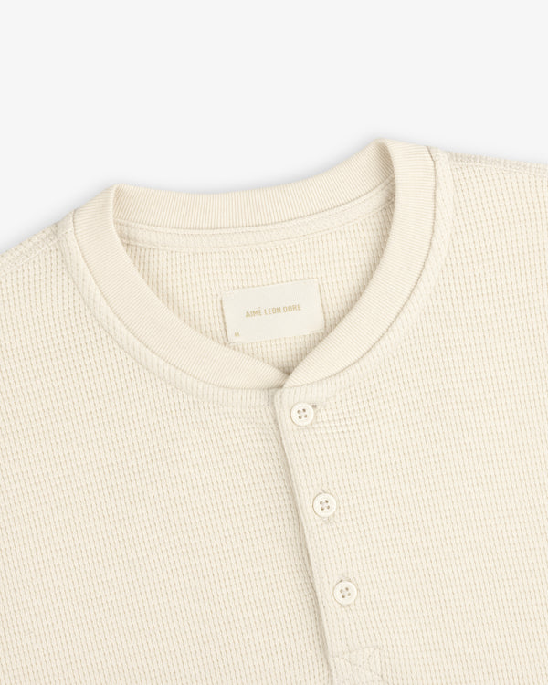 Cream-colored Long-Sleeve Waffle Henley shirt with a waffle-knit texture and a button placket.