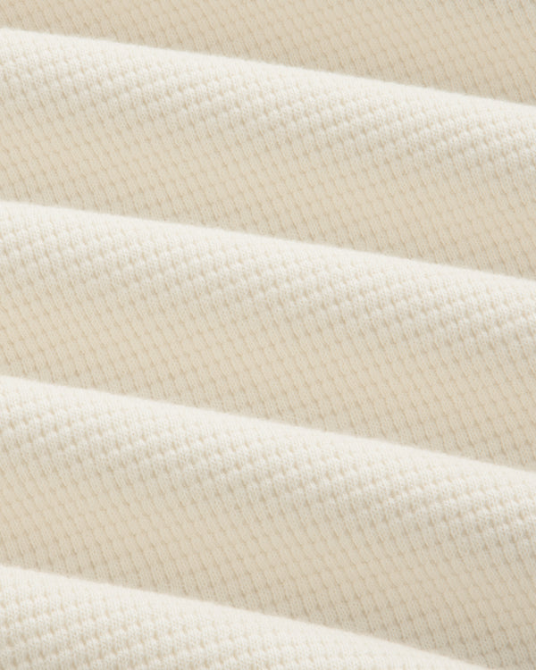 Off-white Long-Sleeve Waffle Henley fabric with a textured waffle-knit pattern in draped folds.