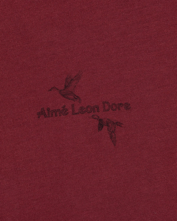 Long-Sleeve Retriever Tee in maroon, featuring a dark print of two flying ducks and the text Aimé Leon Dore.