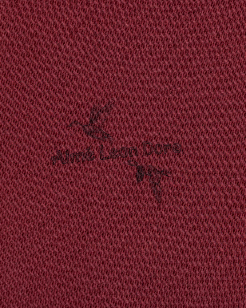 Long-Sleeve Retriever Tee in maroon, featuring a dark print of two flying ducks and the text Aimé Leon Dore.