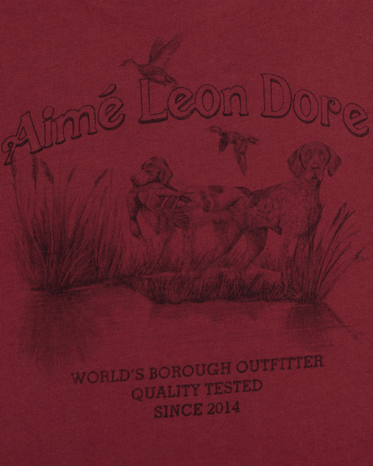 Long-Sleeve Retriever Tee in red with a hunting scene of two dogs and birds above WORLDS BOROUGH OUTFITTER text.