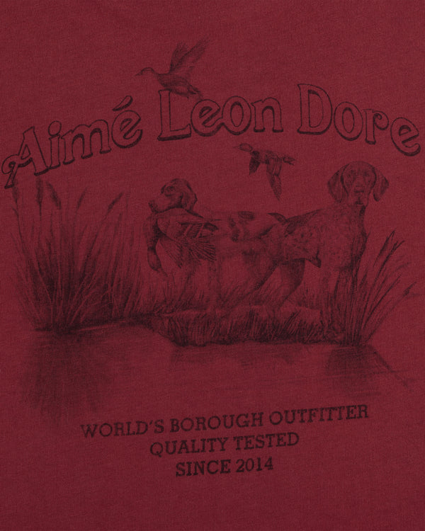 Long-Sleeve Retriever Tee in red with a hunting scene of two dogs and birds above WORLDS BOROUGH OUTFITTER text.