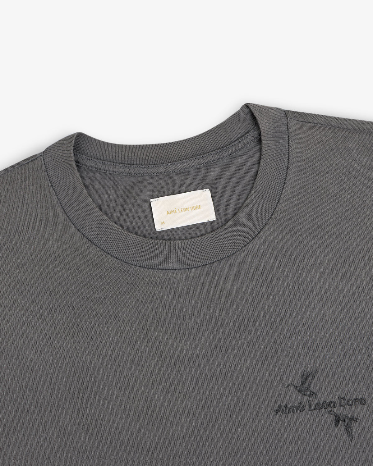 Dark grey Long-Sleeve Retriever Tee with a small embroidered bird design and brand text.