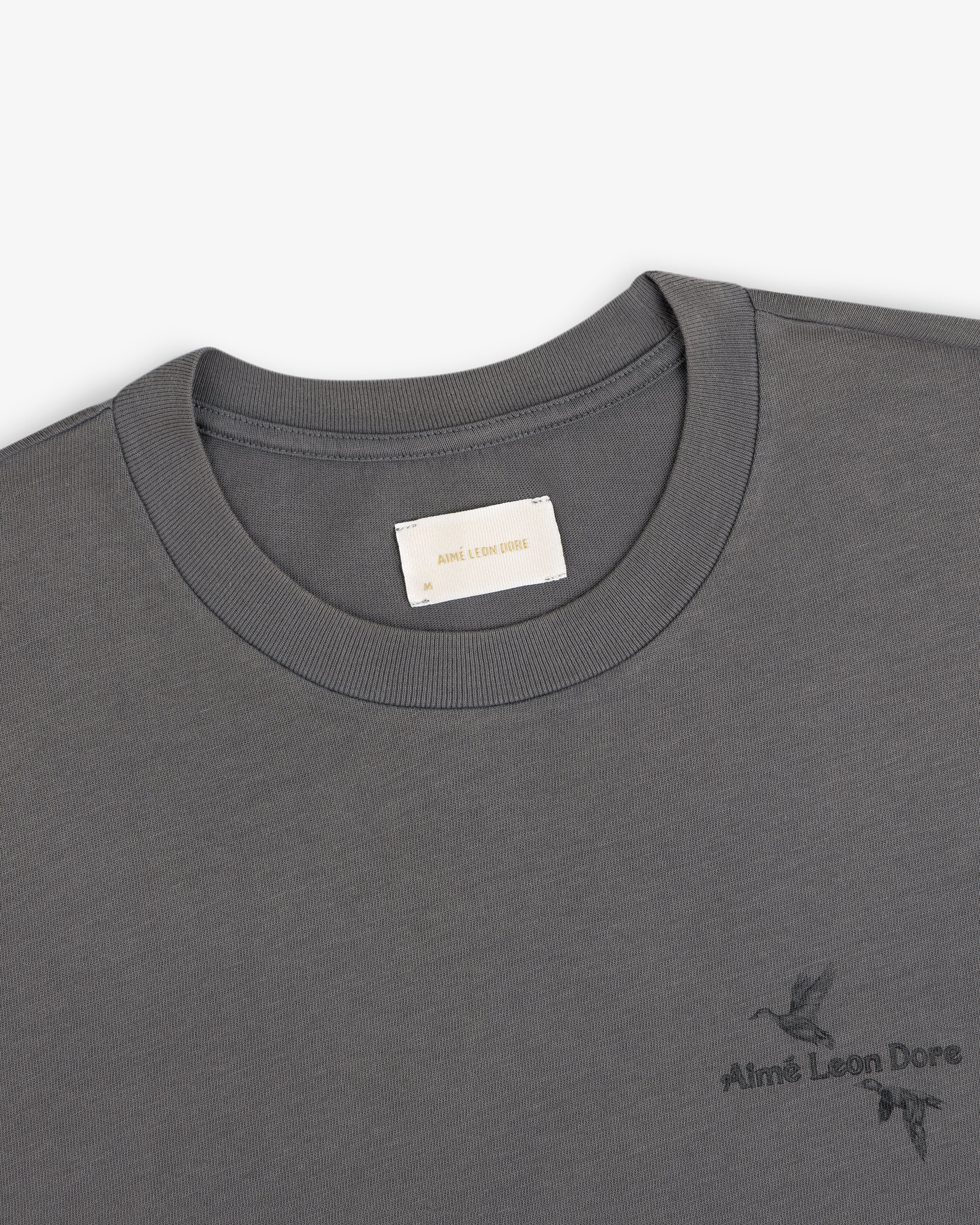 Dark grey Long-Sleeve Retriever Tee with a small embroidered bird design and brand text.