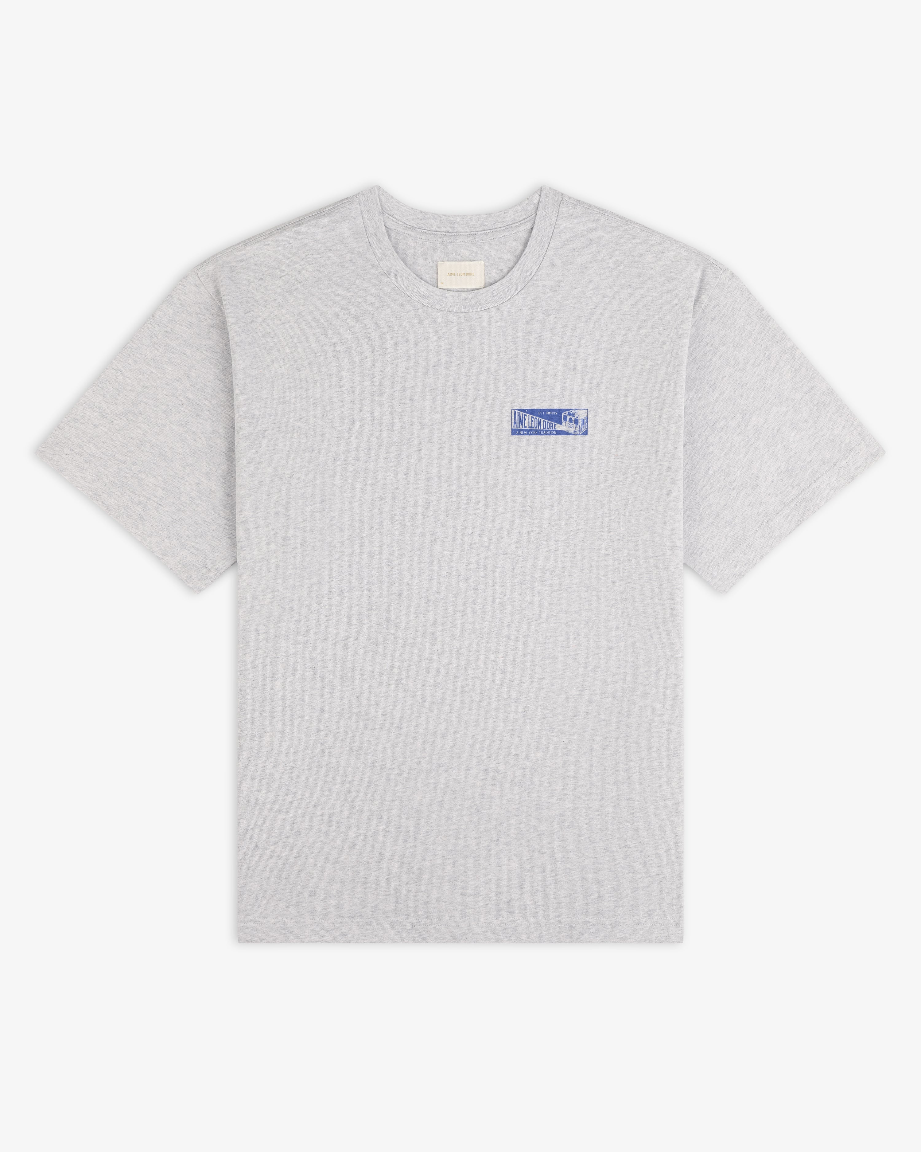 Grey Aimé Transit Tee with a small blue graphic on the left chest.