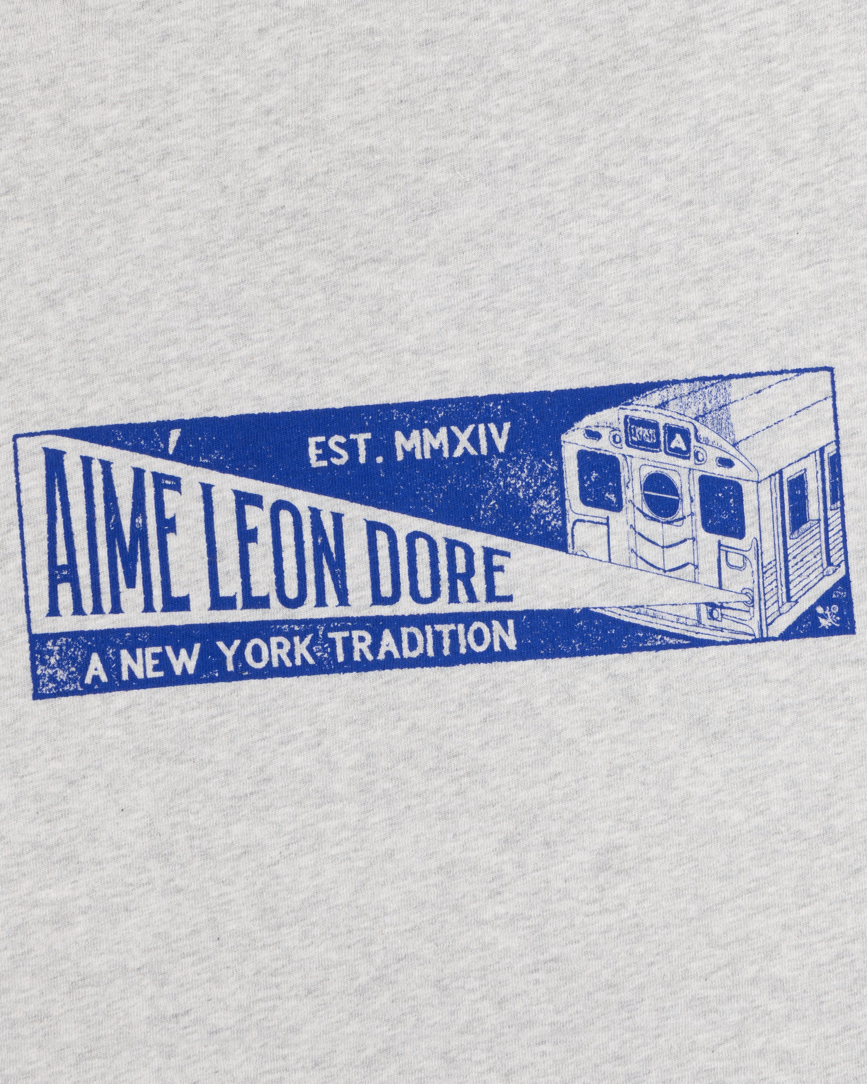 Light gray Aimé Transit Tee with a blue subway car graphic and text reading Aime Leon Dore, Est. MMXIV, A New York Tradition.