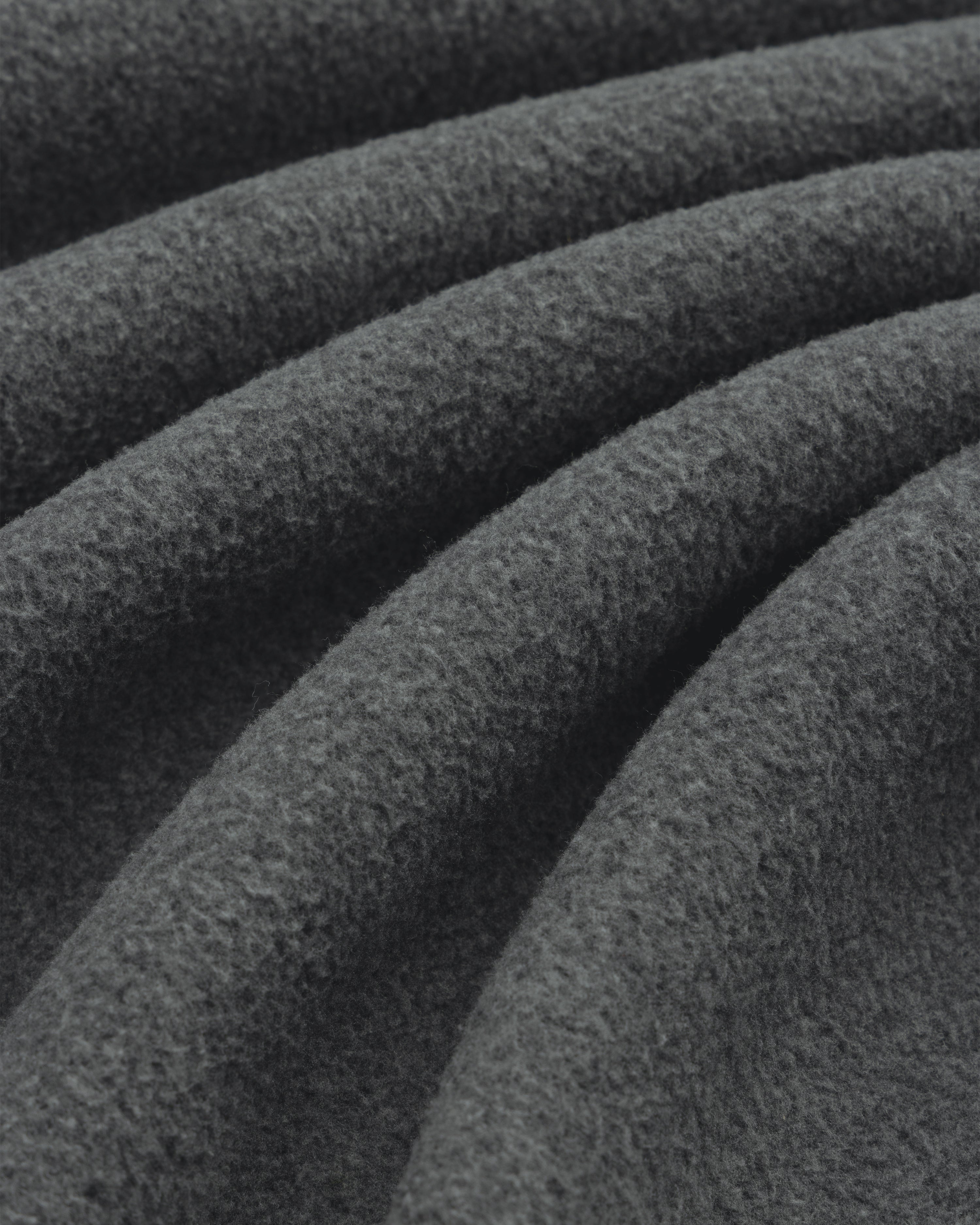 Close-up of Melange Fleece Shirt’s dark gray, textured fabric with soft, wavy folds.