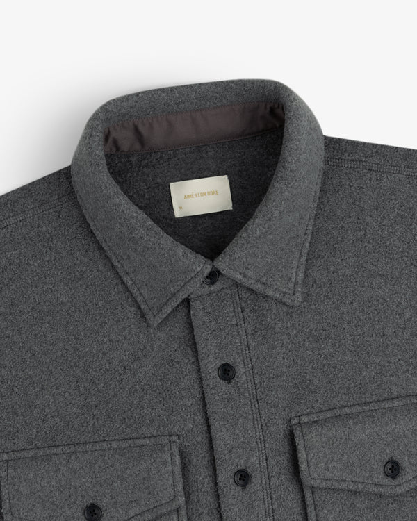 Close-up of Melange Fleece Shirt in gray with collar and two chest pockets, shown on a white background.