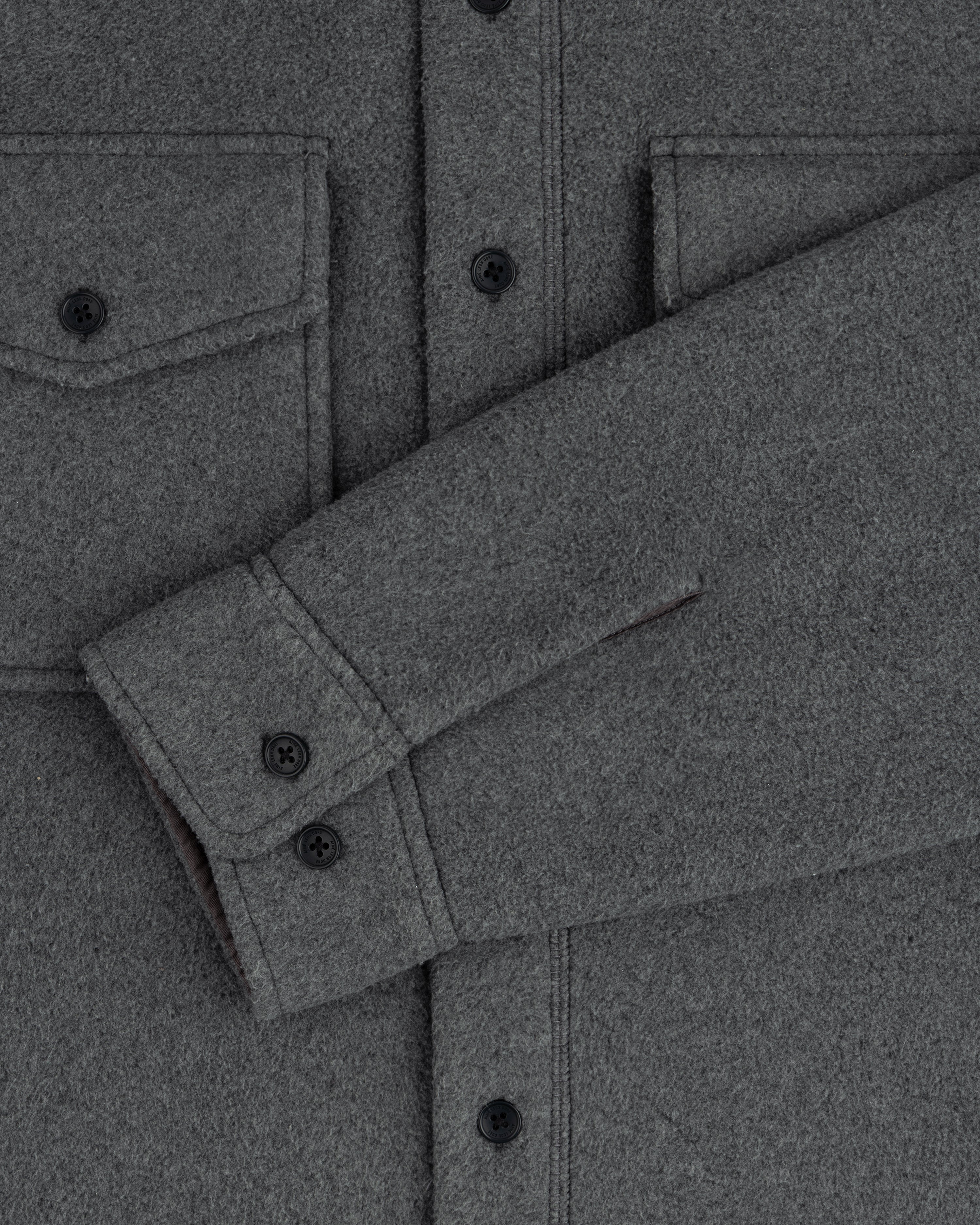 Melange Fleece Shirt: gray wool, black buttons, two chest pockets, sleeve draped diagonally on the front.