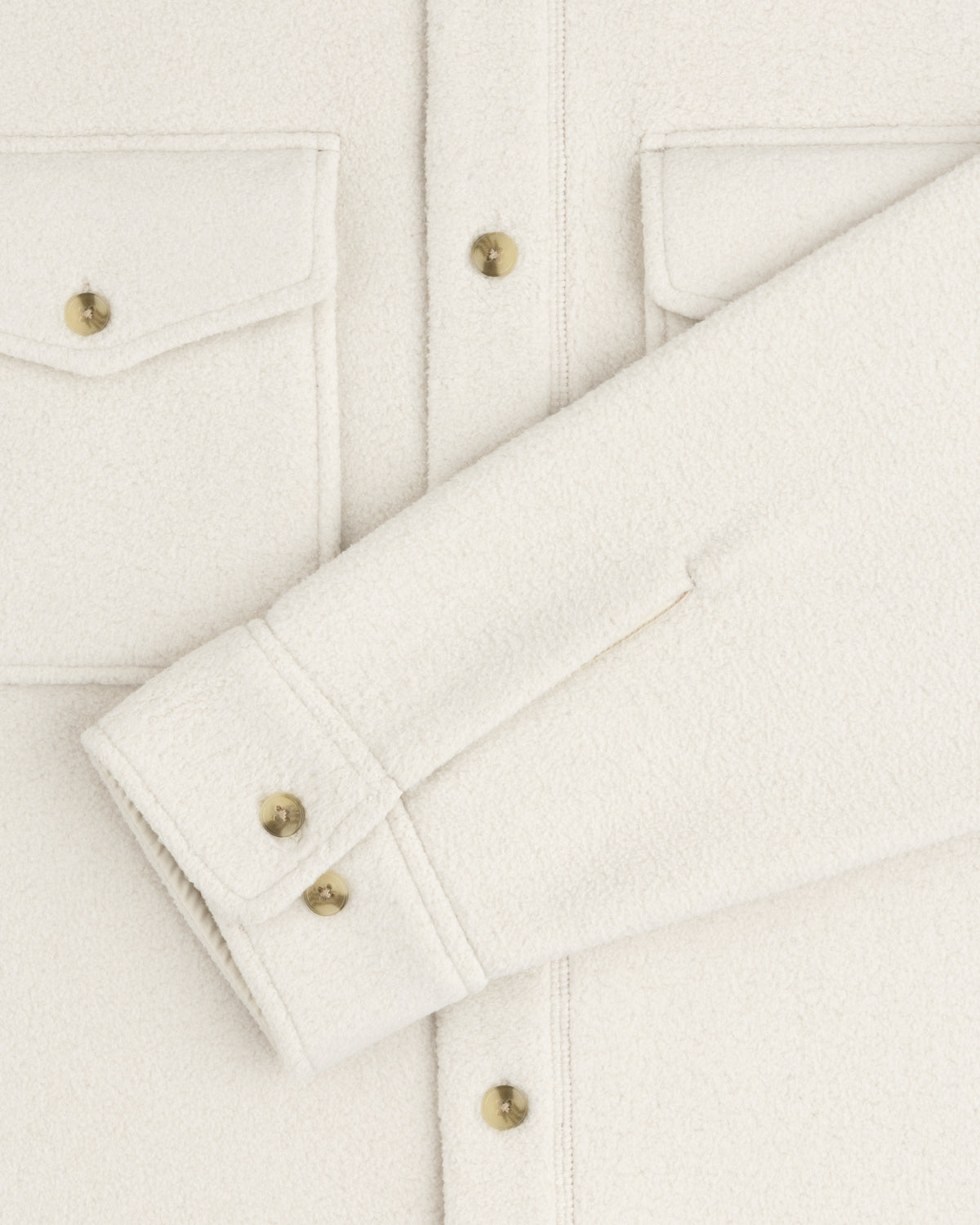 Melange Fleece Shirt in off-white with flap pockets, gold buttons, one sleeve laid flat across the front.
