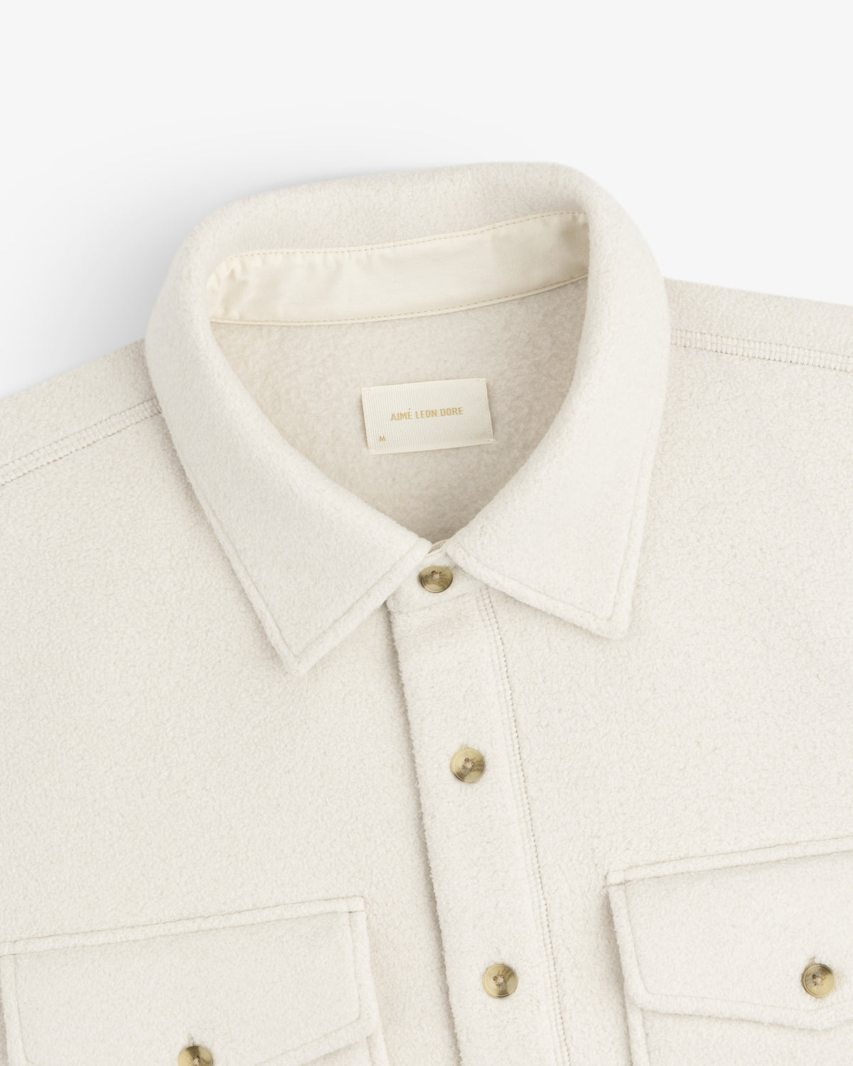 Melange Fleece Shirt in cream with buttons and two front pockets, displayed flat on a white background.