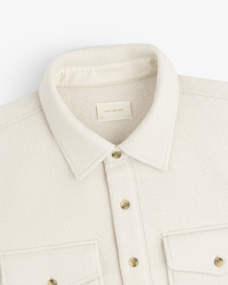 Melange Fleece Shirt in cream with buttons and two front pockets, displayed flat on a white background.