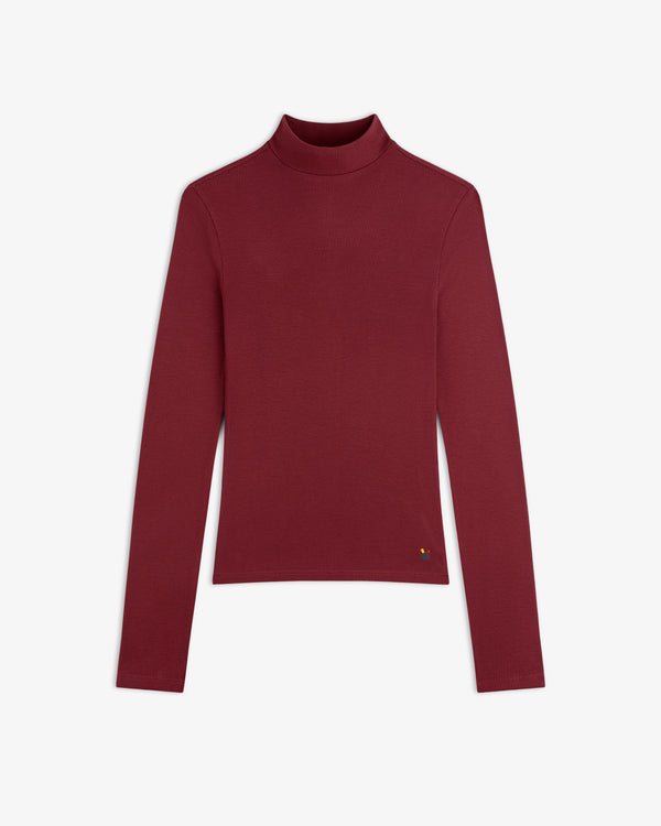 Burgundy Ribbed Mockneck Long-Sleeve Tee with a ribbed texture and a small floral detail on the hem.