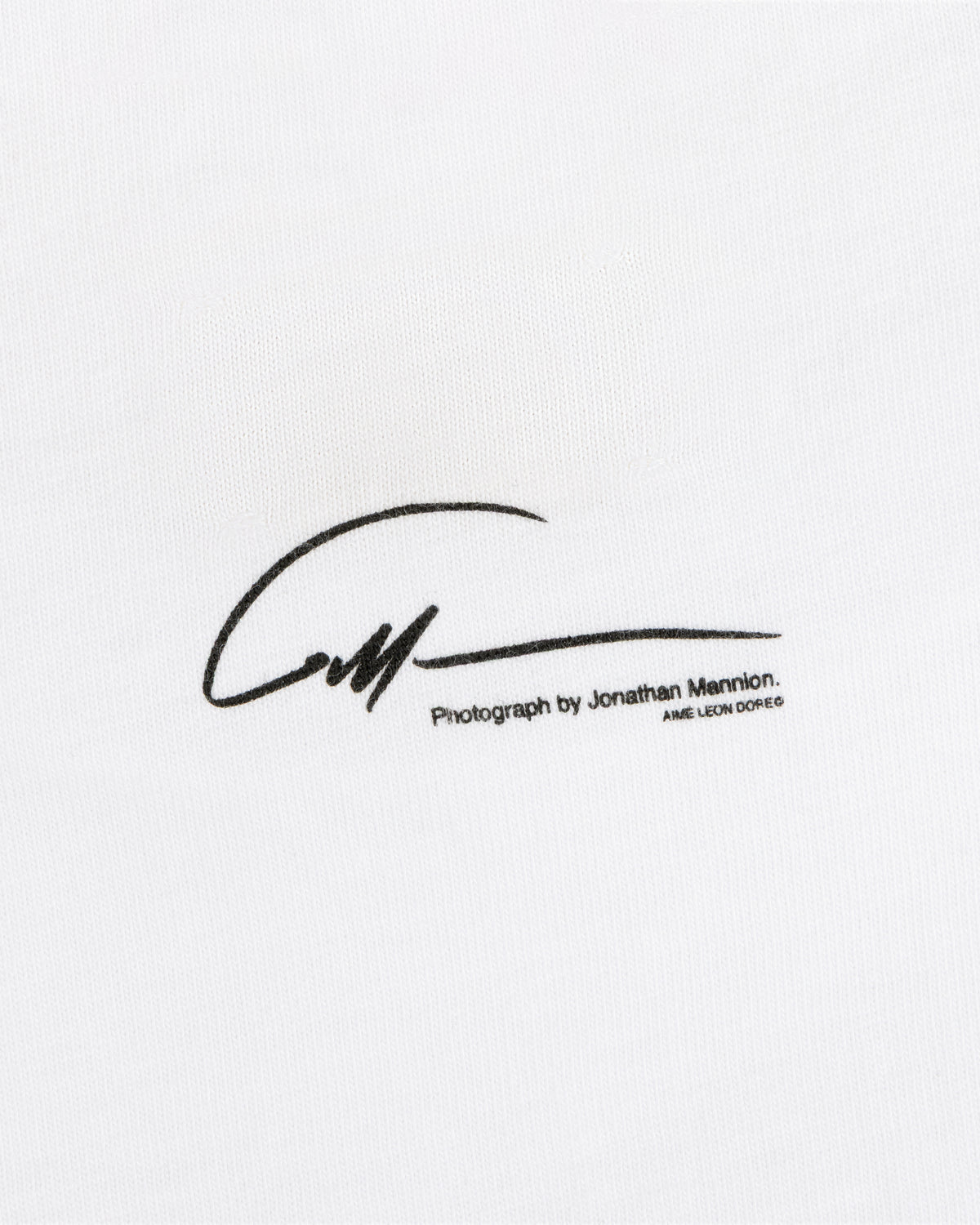 A signature graphic above the text Photograph by Jonathan Mannion on white The Esco Tee fabric.