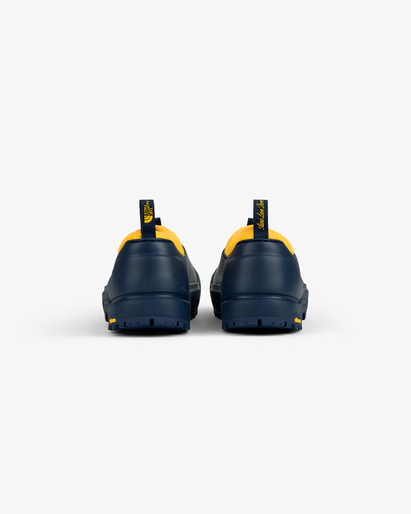 ALD / The North Face Base Camp Mule in navy with yellow trim, rear view, on a plain white background.