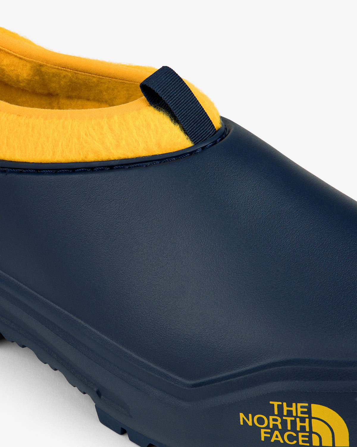 ALD / The North Face Base Camp Mule in navy with yellow lining and side logo, shown close-up.