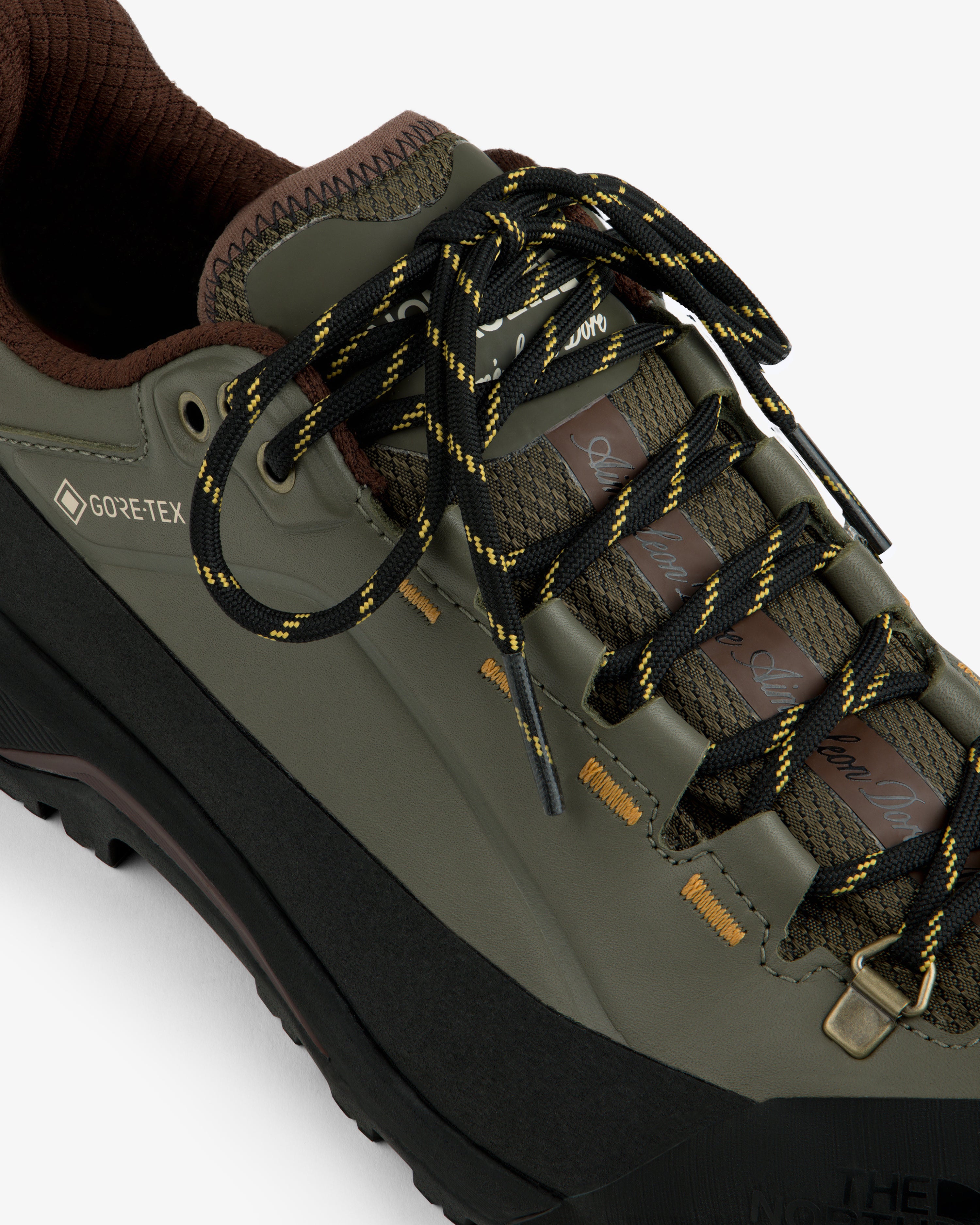ALD/The North Face Verto Alpine Gore-Tex hiking shoe: olive green with black-yellow laces, brown accents, white base.