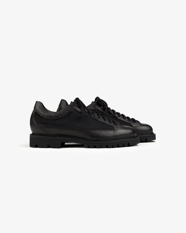 Field Boot: black low-top lace-up shoes with textured leather panels and thick lugged soles.