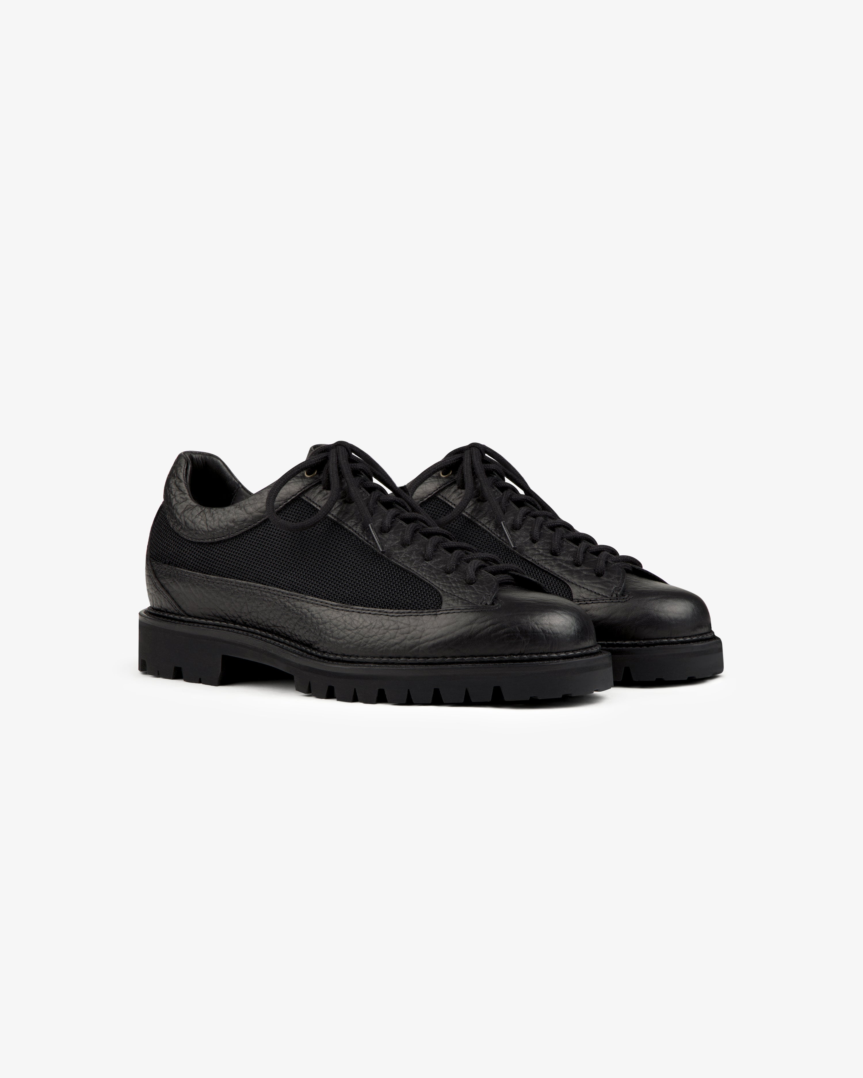 Field Boot black lace-up boots with a textured leather upper and thick lugged rubber soles.