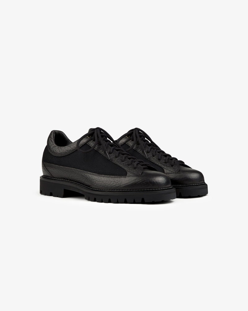 Field Boot black lace-up boots with a textured leather upper and thick lugged rubber soles.