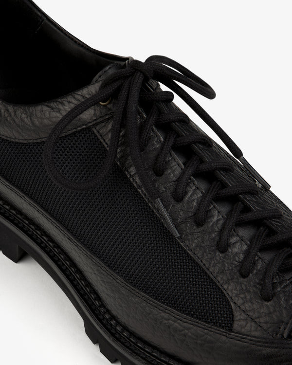 Field Boot in black leather and mesh with a lugged rubber sole and lace-up closure.
