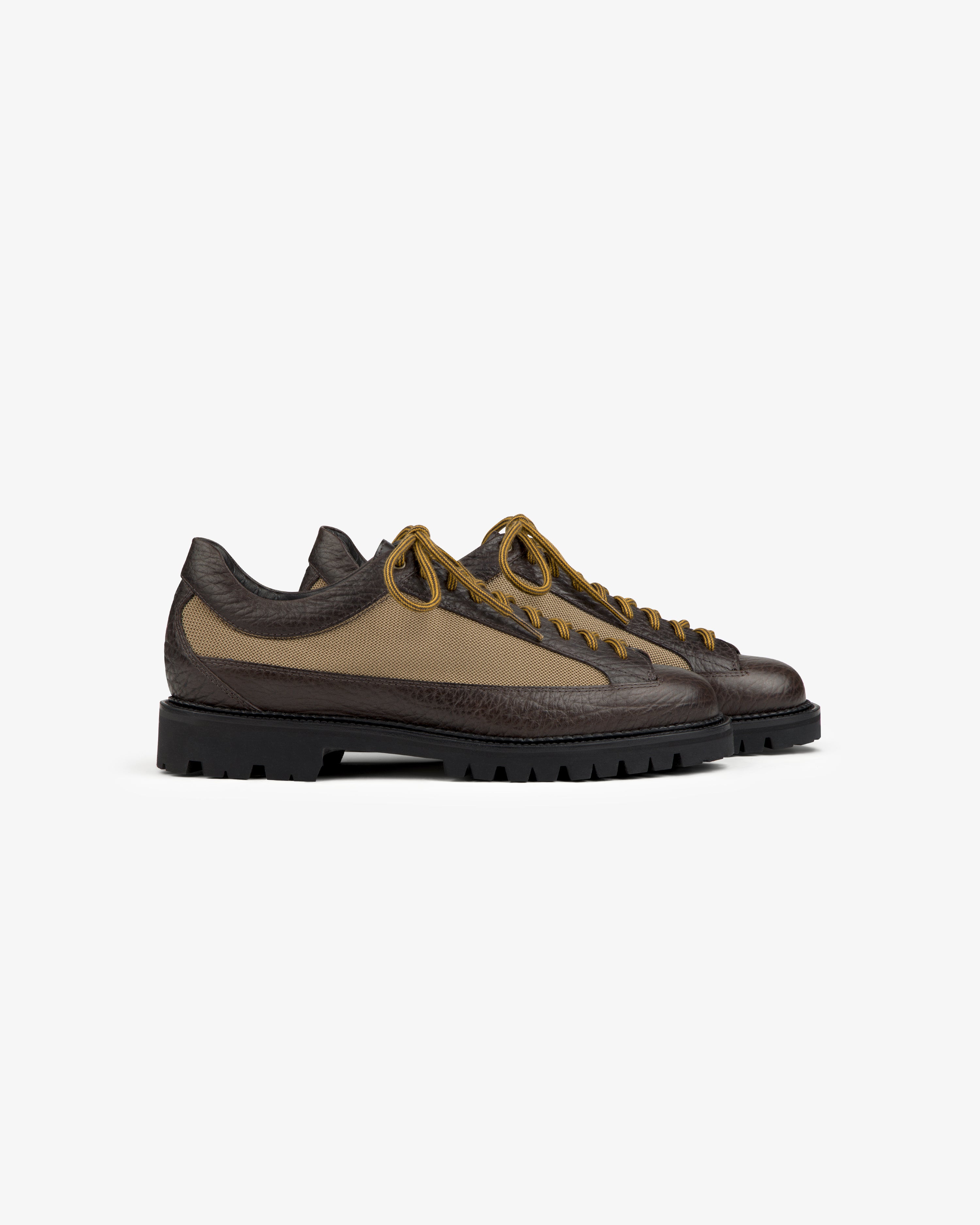 Field Boot in brown with olive canvas side panels, tan laces, and a thick black lug sole.