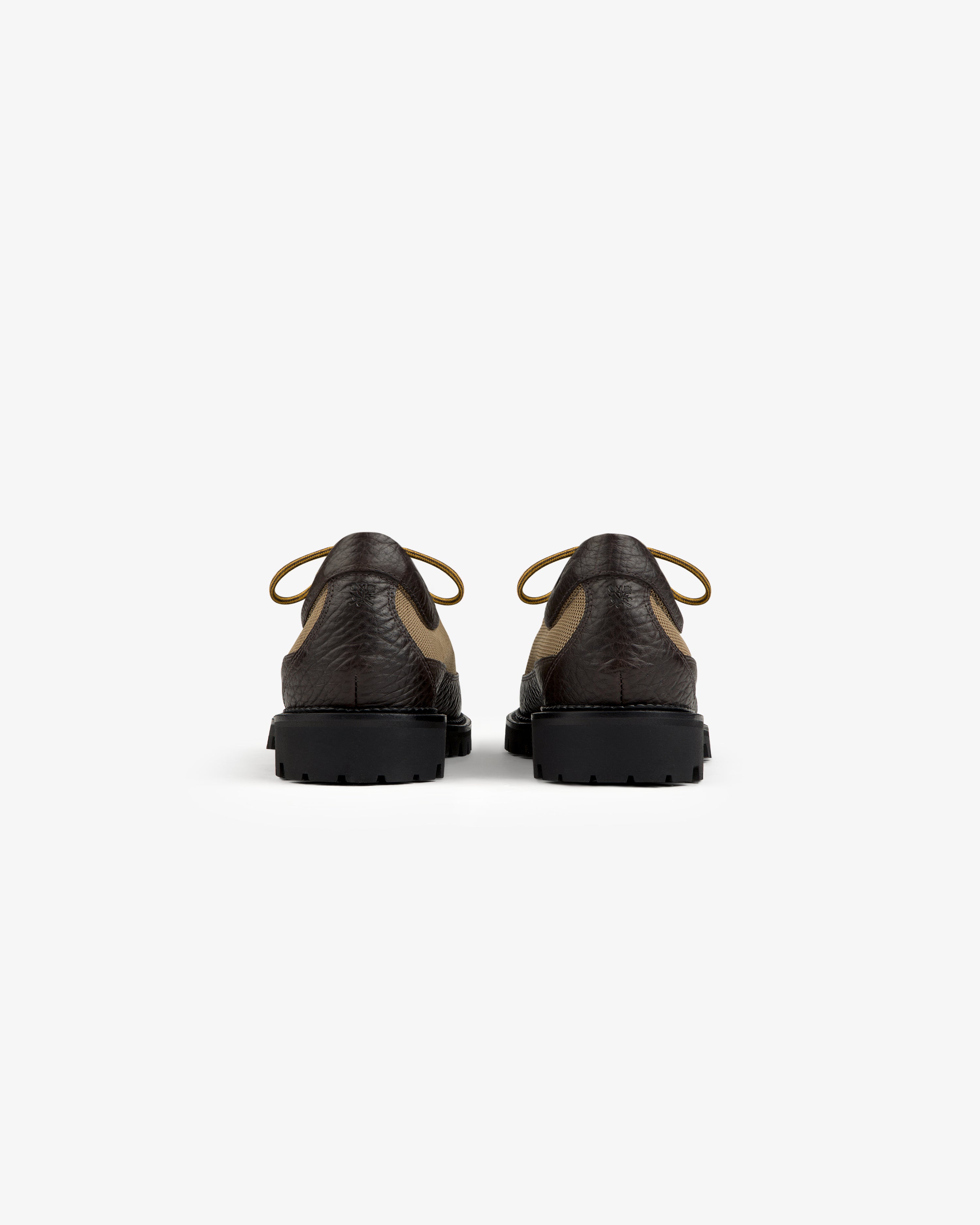 Back view of two brown and tan Field Boot lace-up shoes with thick black lug soles.