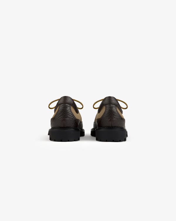 Back view of two brown and tan Field Boot lace-up shoes with thick black lug soles.