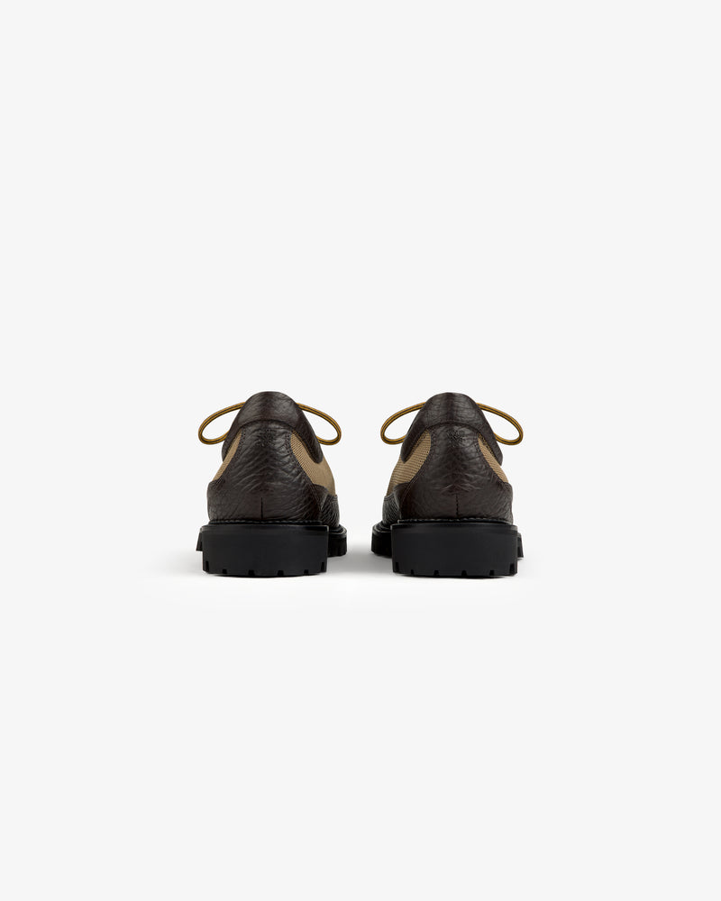 Back view of two brown and tan Field Boot lace-up shoes with thick black lug soles.