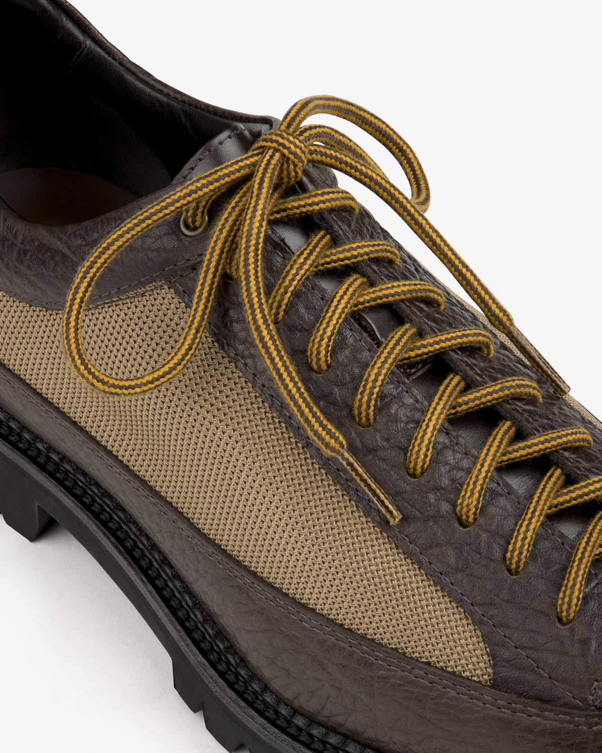 Field Boot in brown leather and tan fabric with yellow-striped laces and a thick lugged sole.