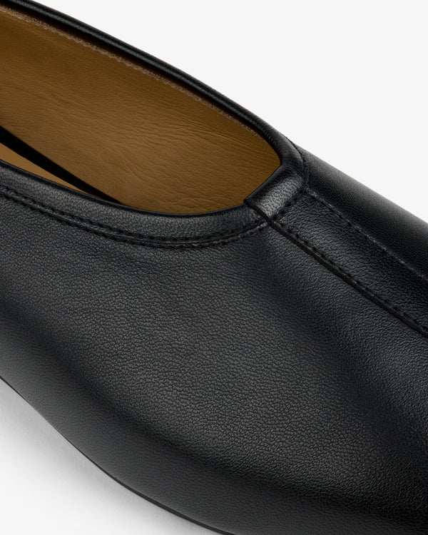 Close-up of a black Leather Ballet Flat featuring a center seam and tan interior lining.